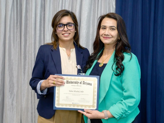 [LAMS Fellowship graduate and GGP division internist Saher Khalid, MD, accepts her SSWIMS graduation certificate from COM-T Assistant Dean Hina Arif, MD.]