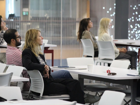 [The DOM’s Francesca Vitali, PhD, an assistant professor of medicine and neurology and Center for Innovation in Brain Science member, listens while students present on research about brain health in HSIB 306.]