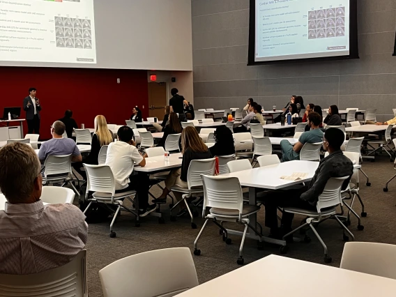 [George Fantry, MD (lower left), a Gastroenterology division associate professor, listens to Class of 2025 med student Jacob Ref discusses his cardiac MRI research in HSIB 306 during a session on Medical Student Research, Scholarly Projects & MD/PhD Trainees.]