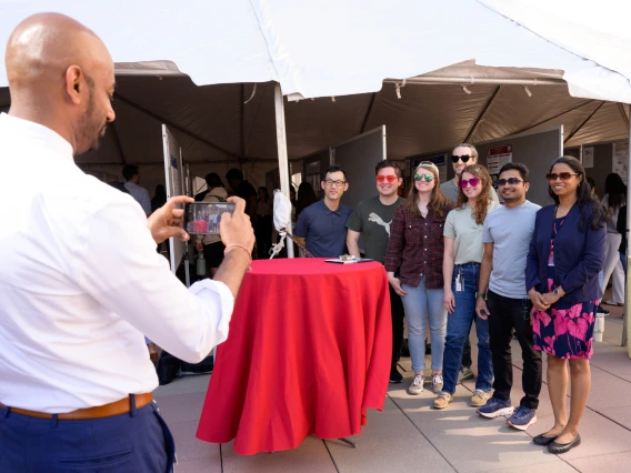 [Sakthi Sadayappan, PhD, chair of the Department of Cellular & Molecular Medicine, takes a photo of presenters from his department participating in the COM-T 2025 Research Day poster session.]