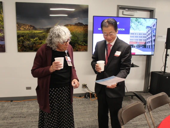 [Mindy Fain, MD, and James K. Liao, MD, chair of the Department of Medicine, look over the agenda for the New Faculty Retreat as the event is about to begin.]