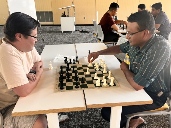 [J’adoube: Nephrology’s Bijin Thajudeen, MD, with hand on his queen, looks for the best place to place her, as Steve Sainbayar, DO (PGY-3 IM resident) strategizes a follow-up move.]