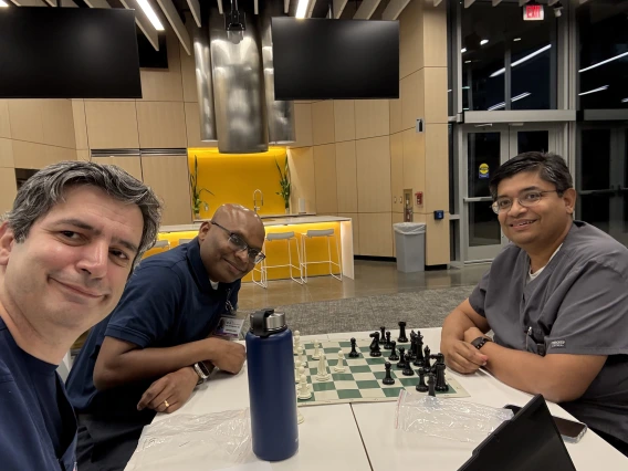[From left, Cardiology’s Talal Moukabary, MD, Nephrology’s Venkatesh Aryamuthu, MD, and Inpatient Medicine’s Anil K. Potharaju, MD — organizers of the evening’s festivities — enjoy a last match of the night, July 7 at the AWCIM Iris Cantor Building: “I was really tired after a long day and still couldn't leave the venue until the doors closed – the people were awesome!” Dr. Potharaju said.]
