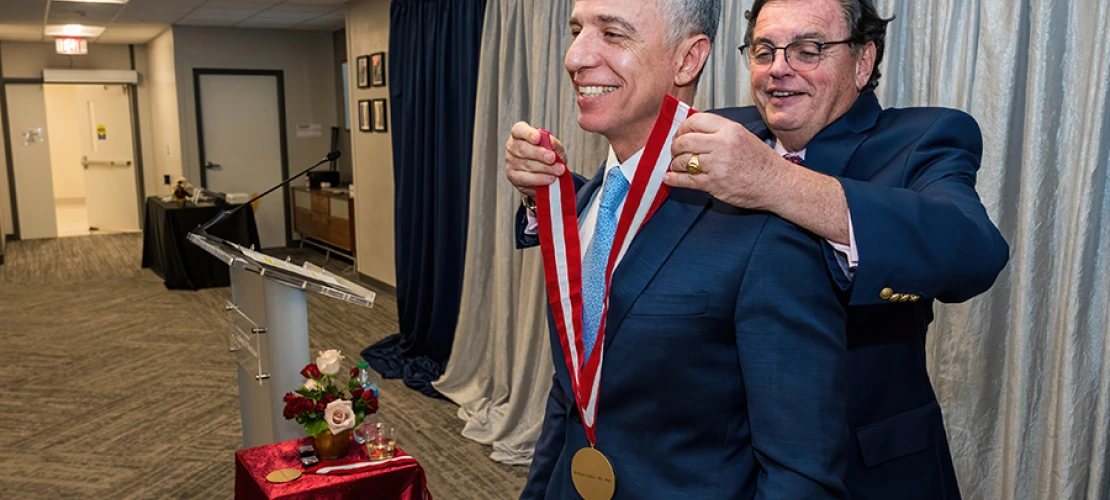 College of Medicine – Tucson Dean Michael Abecassis, MD, MBA, places the investiture medallion on Hesham Sadek, MD, PhD, Cardiology division chief and Sarver Heart Center director.