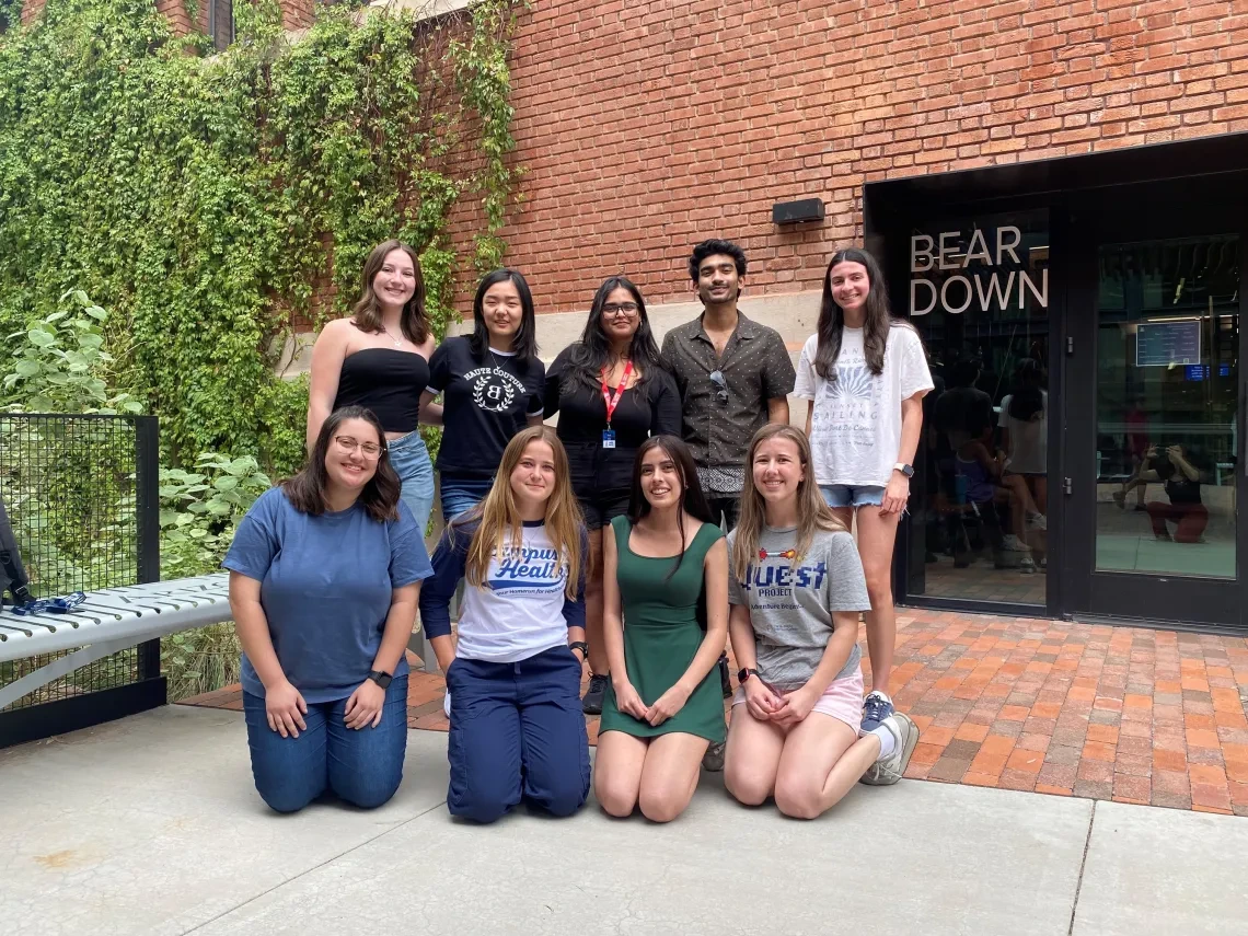 Students gather outside the Bear Town building, posing together for a cheerful group photo, highlighting their unity.