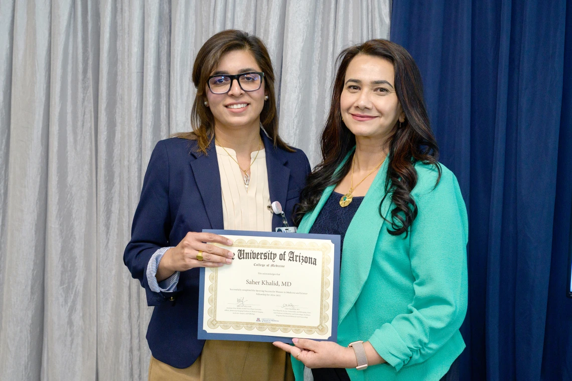 [LAMS Fellowship graduate and GGP division internist Saher Khalid, MD, accepts her SSWIMS graduation certificate from COM-T Assistant Dean Hina Arif, MD.]