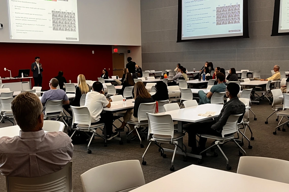 [George Fantry, MD (lower left), a Gastroenterology division associate professor, listens to Class of 2025 med student Jacob Ref discusses his cardiac MRI research in HSIB 306 during a session on Medical Student Research, Scholarly Projects & MD/PhD Trainees.]