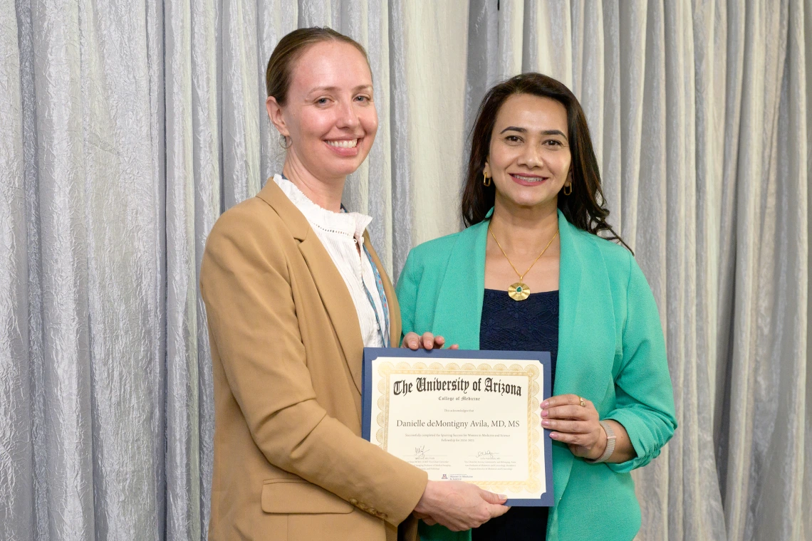 [The Infectious Diseases division’s Danielle Avila, MD, accepts her LAMS graduation certificate from COM-T Assistant Dean Hina Arif, MD.]