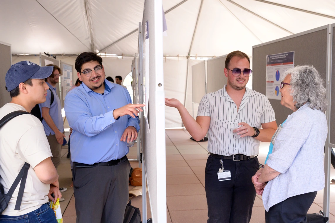 [Mindy Fain, MD, chief, Division of General Internal Medicine, Geriatrics & Palliative Medicine, chats with Daniel Benson, MEng — a PhD candidate working in the lab of the Division of Cardiology’s Steven Goldman, MD — about his poster on display April 29 at the belated Poster Session for COM-T Research Day.]