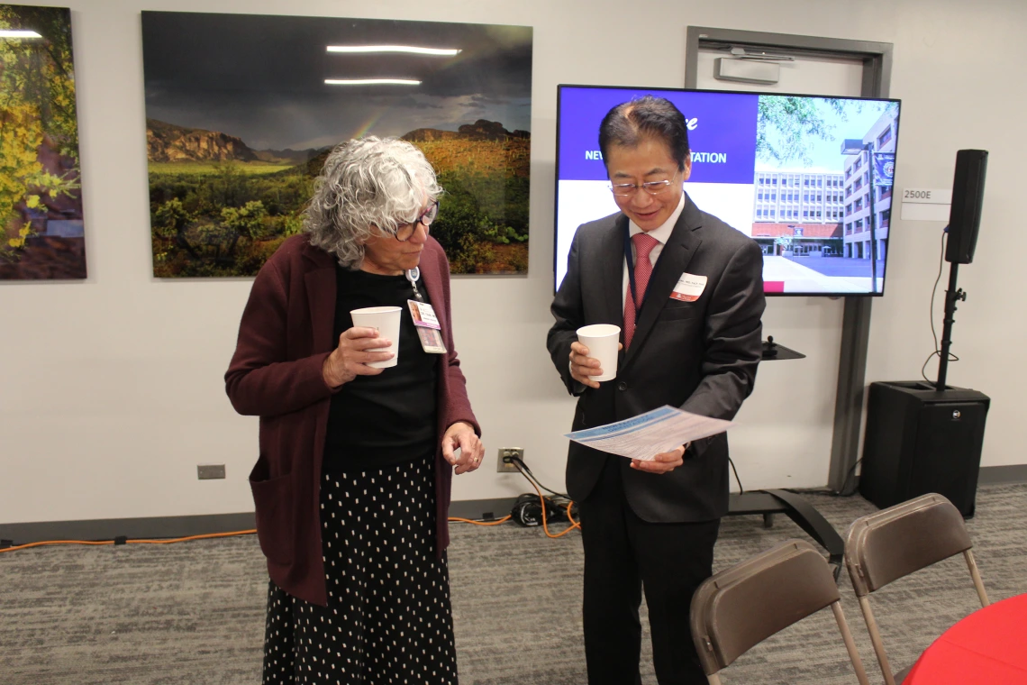 [Mindy Fain, MD, and James K. Liao, MD, chair of the Department of Medicine, look over the agenda for the New Faculty Retreat as the event is about to begin.]