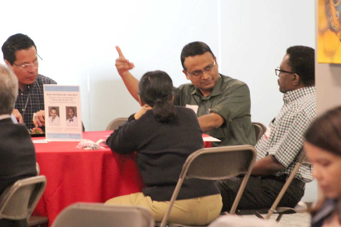 [Bijin Thajudeen, MD, DOM vice chair of community engagement & partnerships, gestures as he speaks to James Doe, MD, a clinical assistant professor in the Division of General Internal Medicine, Geriatrics & Palliative Medicine.]